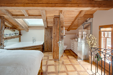 Chalet Schatzchischta Zermatt - Schlafzimmer mit Eckbadewanne